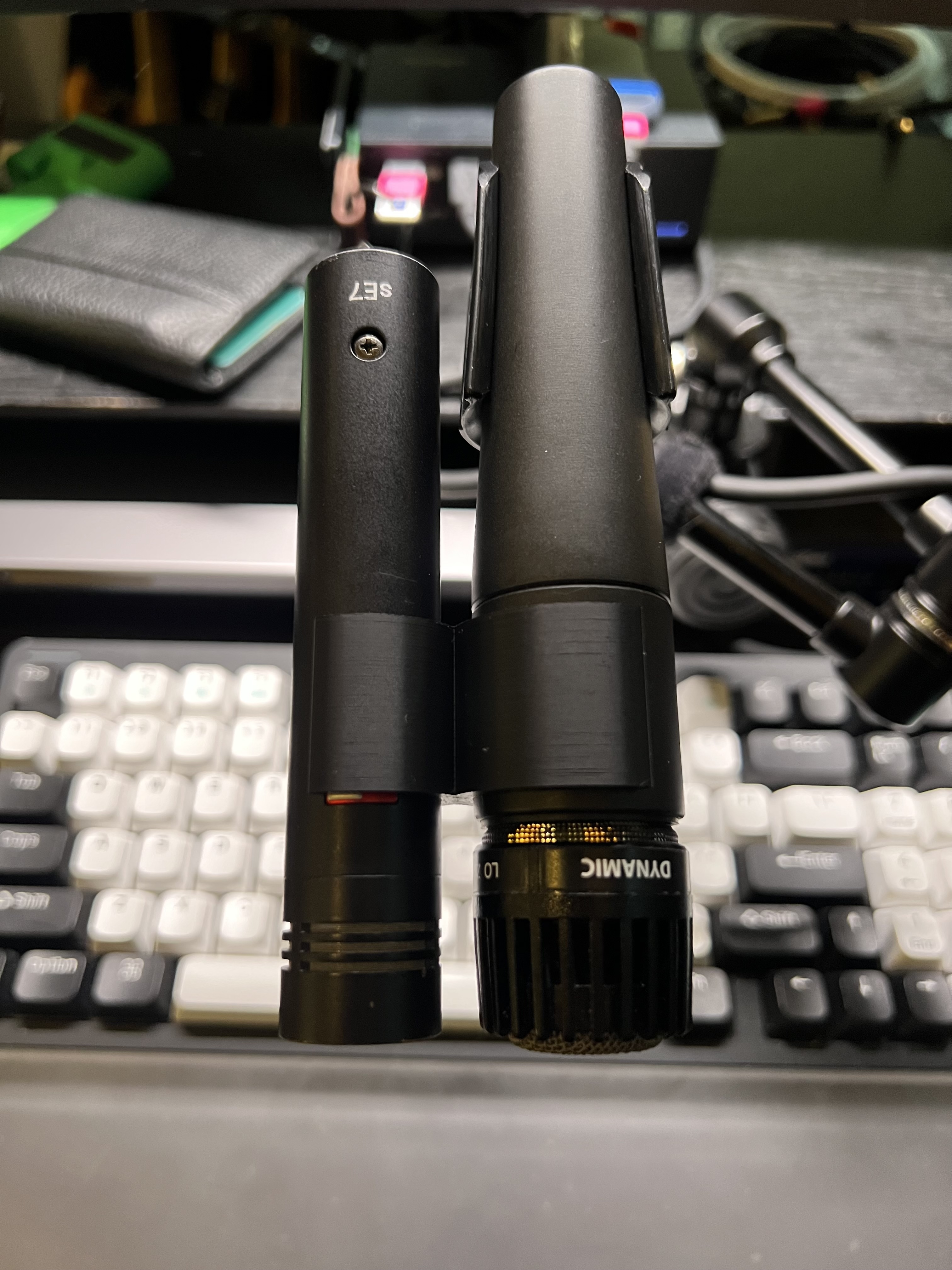 A 3D printed microphone clip, holding a Shure SM57 and an sE7